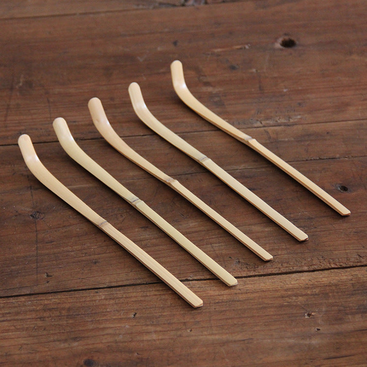 five matcha bamboo scoops on a wooden table