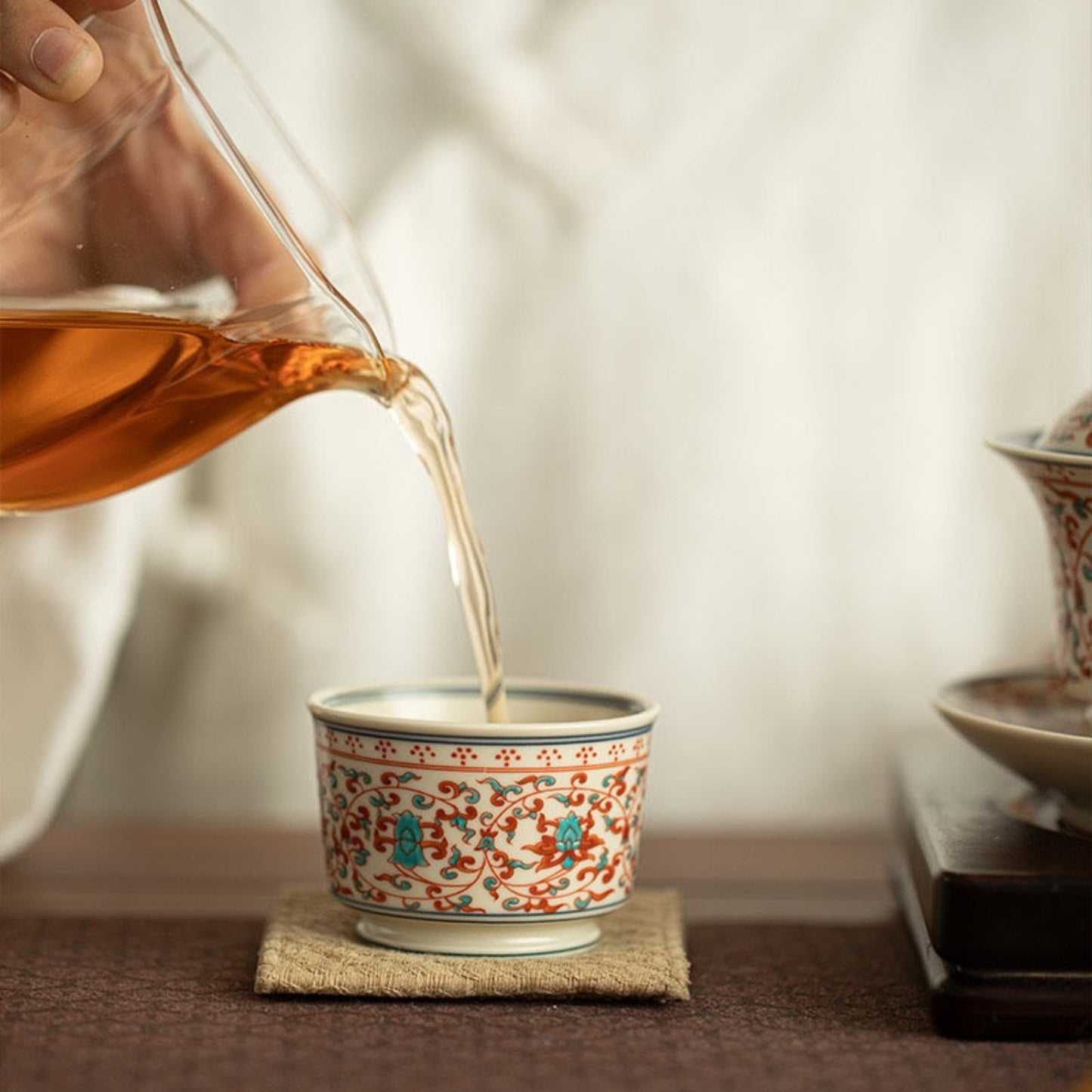 pouring tea in a fencai tea cup 