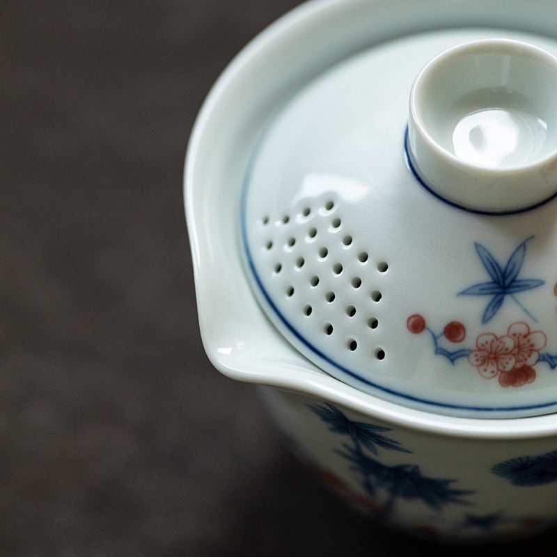 Close-up of a ceramic teapot with floral designs on a dark background