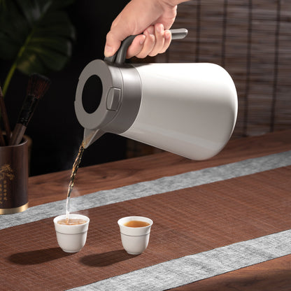 pouring tea in a cup with a thermos jug