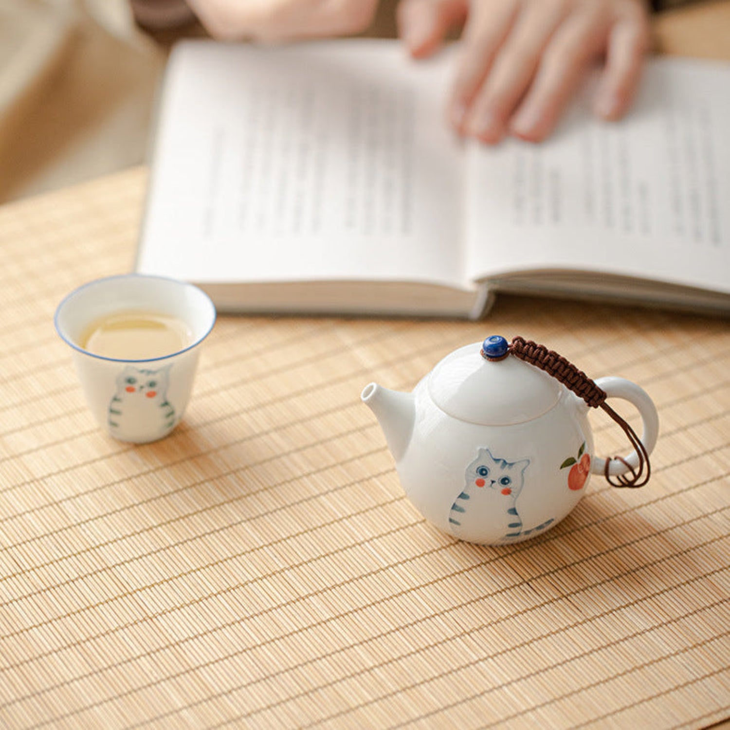 teapot and matching cup with a book