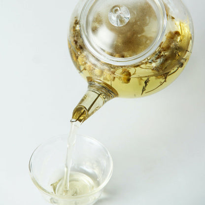 pouring flower tea with a glass teapot
