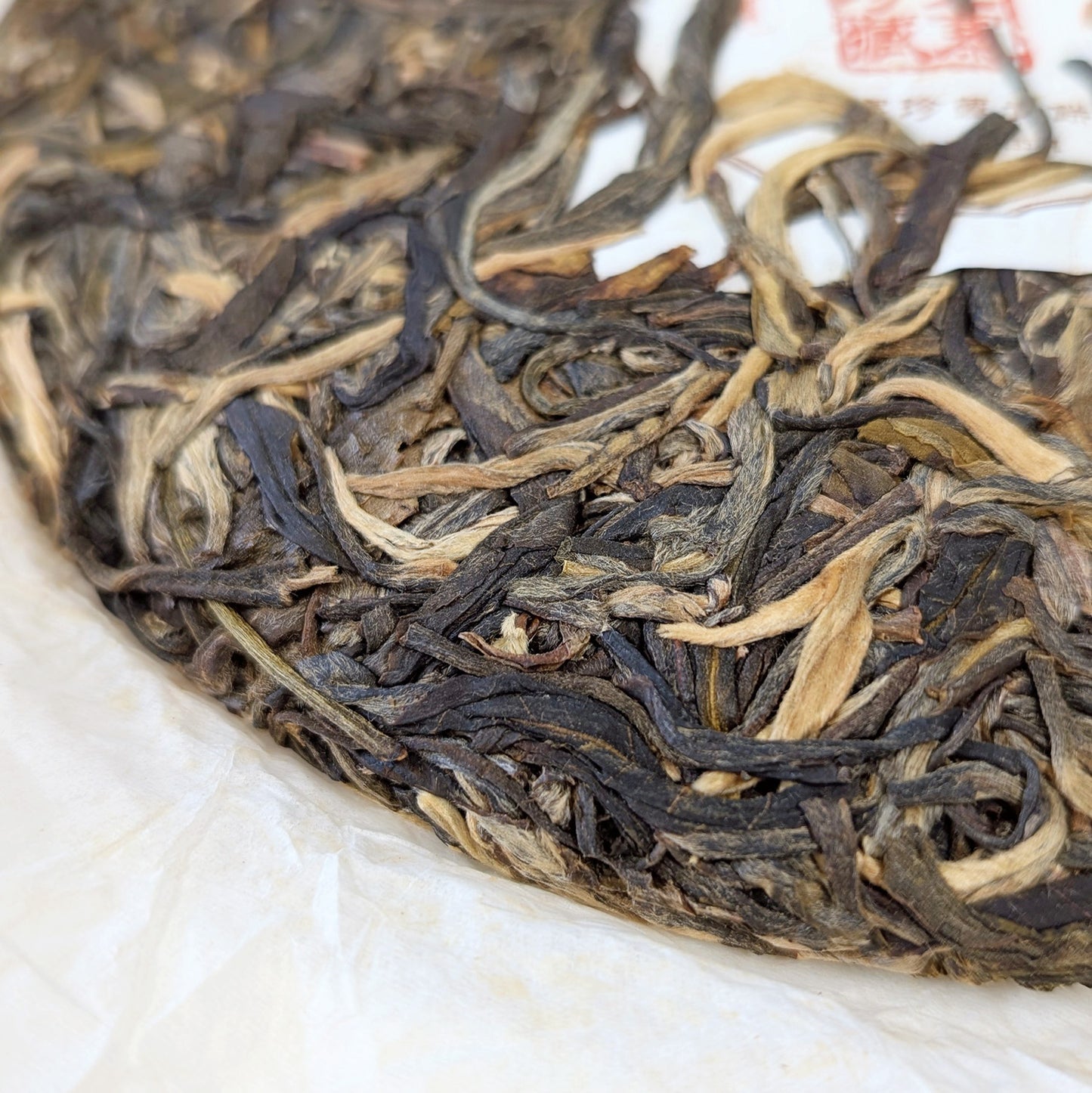detail of compressed tea leaves and golden buds - pu erh tea cake 