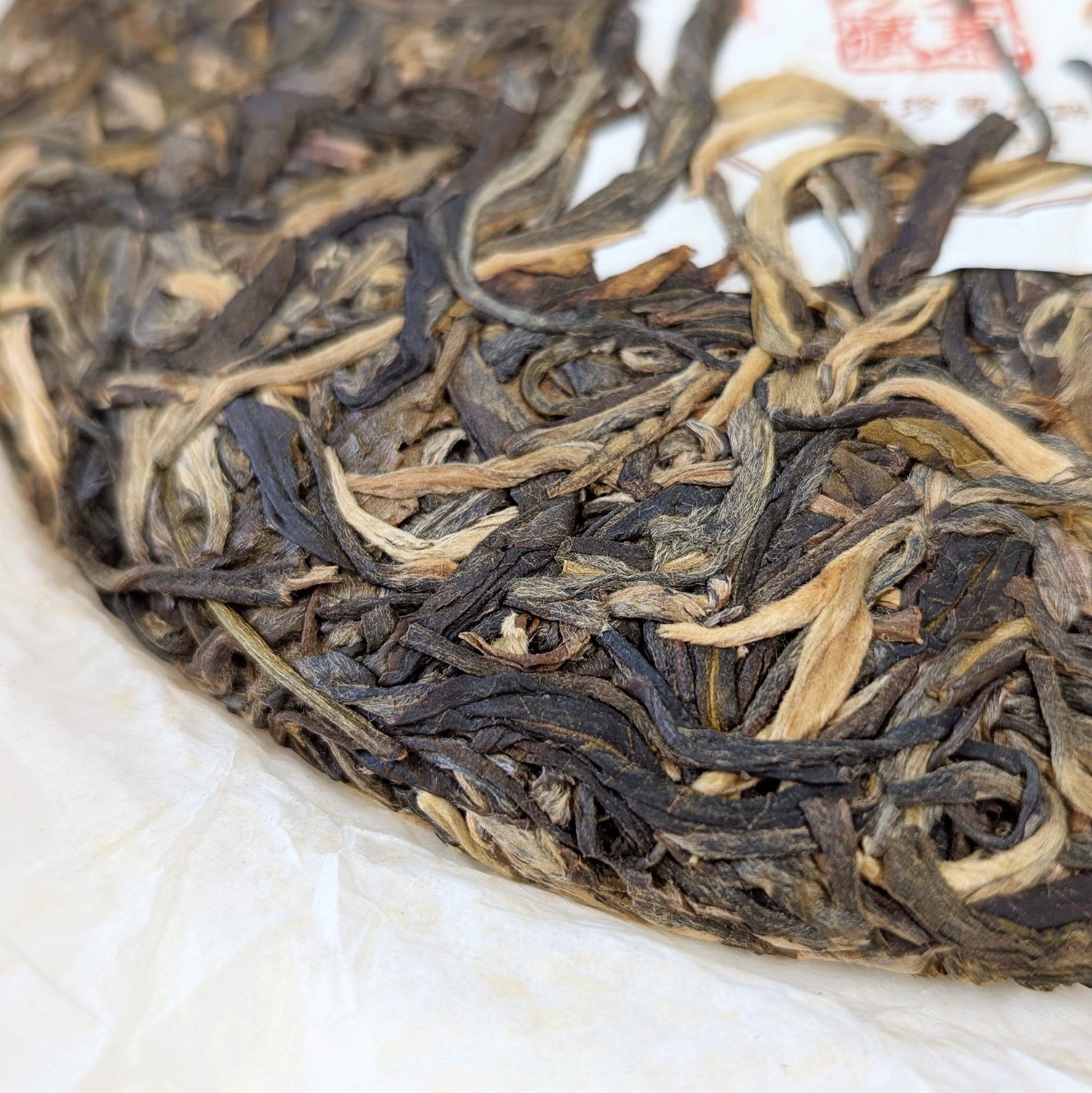 detail of compressed tea leaves and golden buds - pu erh tea cake 