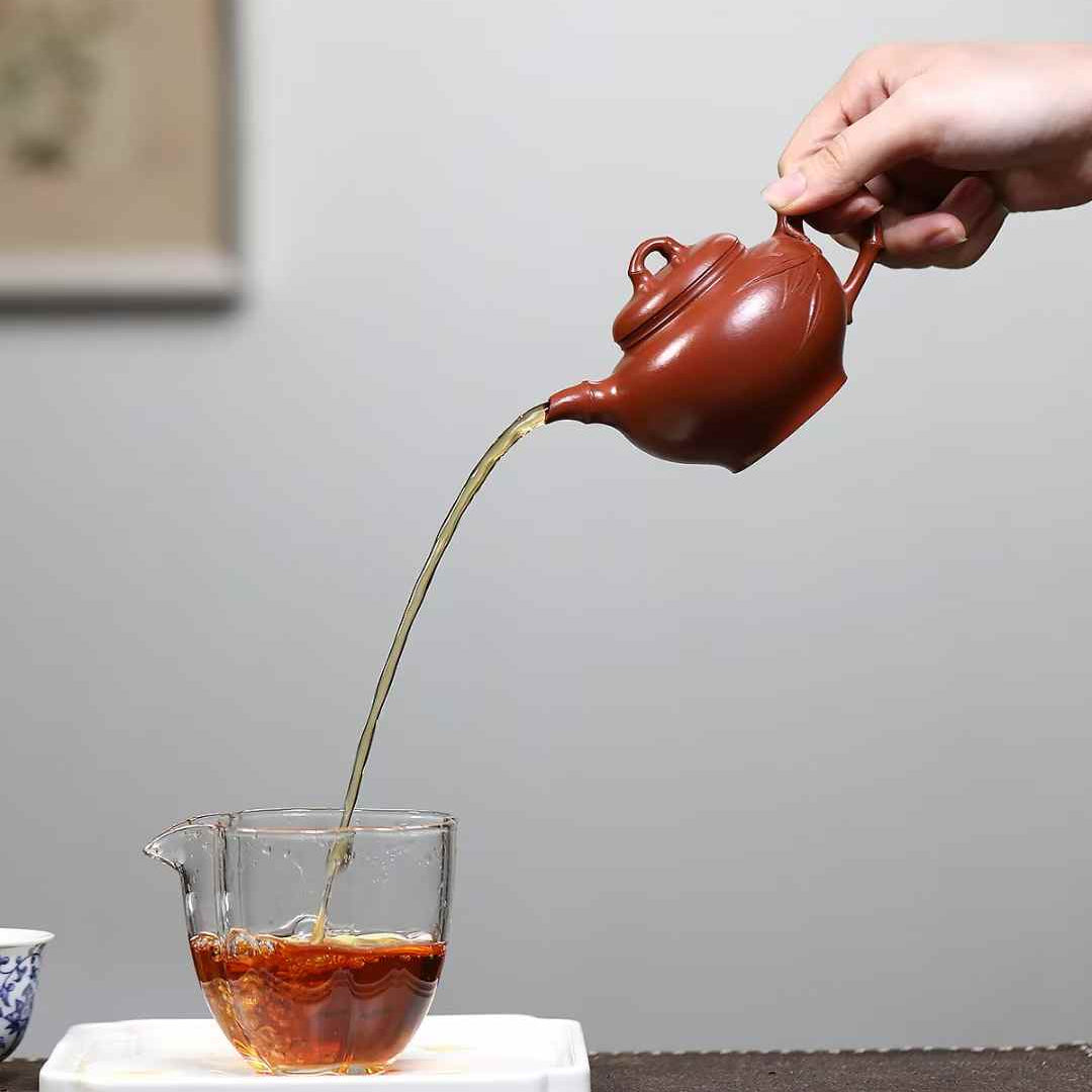 ripe pu erh tea is poured with a Yixing teapot in a pitcher